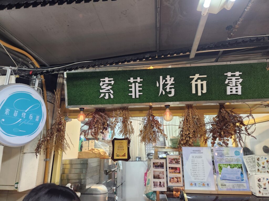 索菲烤布蕾-櫃檯上擺了價目表、名人用餐照及獎牌，展現店家的用心